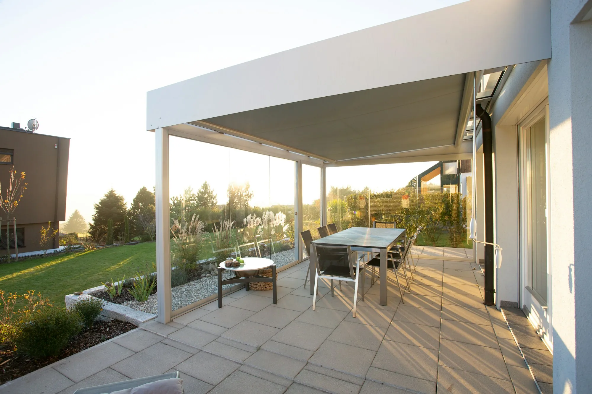Covered concrete patio with a dining table and garden view